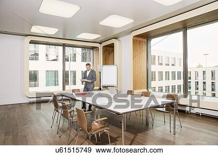 Stock Photo - Businessman standing in conference room. Fotosearch