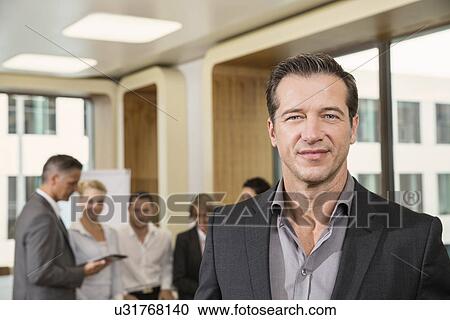 Businessman standing in front of colleagues View Large Photo Image Stock Image - Businessman standing in front of colleagues. Fotosearch