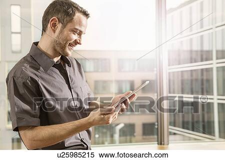 Stock Photography - Businessman using digital tablet. Fotosearch