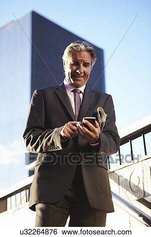 Stock Photograph - Businessman using smartphone. Fotosearch