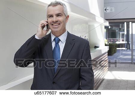 Businessman walking down corridor in office View Large Photo Image Stock Photo - Businessman walking down corridor in office. Fotosearch
