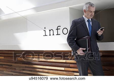 Stock Photo - Businessman walking down corridor in office. Fotosearch