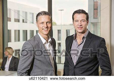 Businessmen standing in conference room View Large Photo Image Stock Image - Businessmen standing in conference room. Fotosearch
