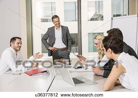 Stock Image - Businesspeople meeting in conference room. Fotosearch