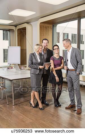 Businesspeople standing in conference room View Large Photo Image Stock Image - Businesspeople standing in conference room. Fotosearch