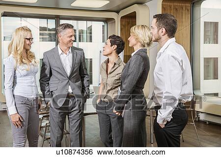 Businesspeople standing in conference room View Large Photo Image Stock Photograph - Businesspeople standing in conference room. Fotosearch
