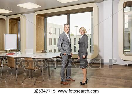 Stock Photography - Businesspeople standing in conference room. Fotosearch