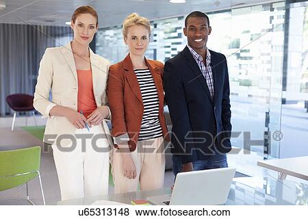 Businesspeople standing in office View Large Photo Image Stock Photo - Businesspeople standing in office. Fotosearch