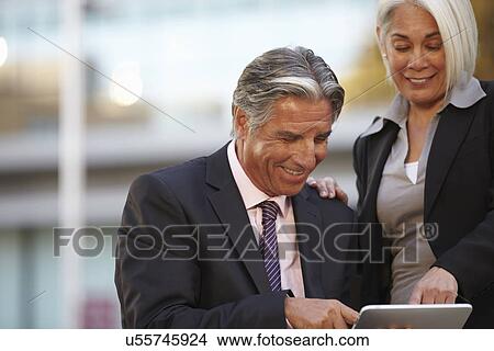 Picture - Businesspeople using digital tablet. Fotosearch