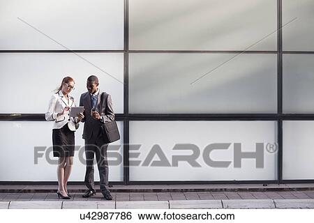 Stock Photograph - Businesspeople using digital tablet. Fotosearch