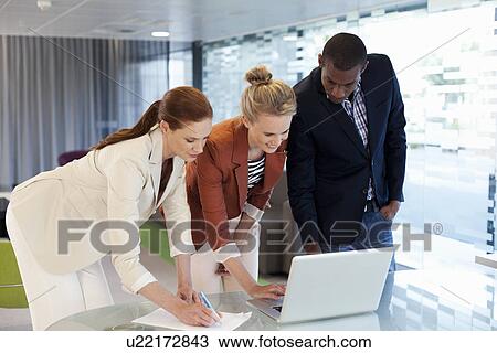 Businesspeople working on laptop and writing activity View Large Photo Image Stock Image - Businesspeople working on laptop and writing activity. Fotosearch