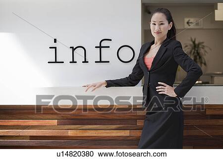 Businesswoman standing at info desk View Large Photo Image Stock Image - Businesswoman standing at info desk. Fotosearch