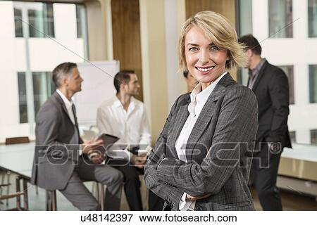 Businesswoman standing in front of colleagues View Large Photo Image Stock Photo - Businesswoman standing in front of colleagues. Fotosearch