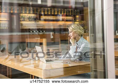 Businesswoman using laptop, view through window View Large Photo Image Stock Photography - Businesswoman using laptop, view through window. Fotosearch