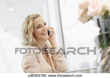 Businesswoman using mobile phone in office View Large Photo Image Stock Photography - Businesswoman using mobile phone in office. Fotosearch