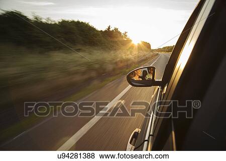 Car driving along road, reflection in wing mirror View Large Photo Image Stock Photo - Car driving along road, reflection in wing mirror. Fotosearch