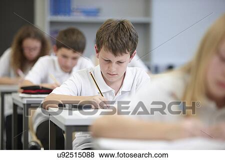 Stock Photo - Class of schoolchildren doing educational exam. Fotosearch