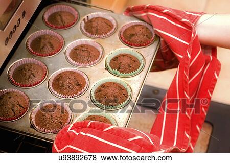 Close up of hands removing cupcakes from oven View Large Photo Image Stock Photo - Close up of hands removing cupcakes from oven. Fotosearch