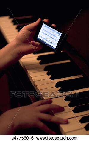 Close up of hands using smartphone whilst playing piano View Large Photo Image Stock Photograph - Close up of hands using smartphone whilst playing piano. Fotosearch