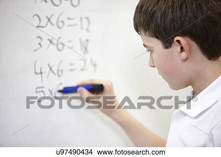 Close up of schoolboy doing multiplication on white board View Large Photo Image Picture - Close up of schoolboy doing multiplication on white board. Fotosearch