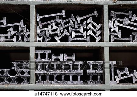 Stock Photo - Close up of shelves and metal components in printing workshop. Fotosearch
