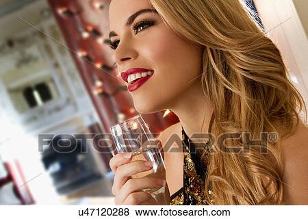 Stock Photo - Close up of young woman with glass of champagne. Fotosearch