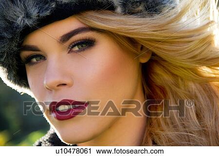 Stock Image - Close up portrait of young woman in fur hat. Fotosearch