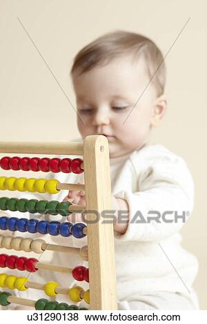 Close up studio portrait of baby girl playing with abacus View Large Photo Image Stock Photo - Close up studio portrait of baby girl playing with abacus. Fotosearch