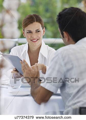 Stock Photo - Couple choosing from menu in hotel restaurant. Fotosearch