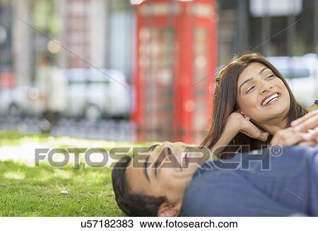 Couple lying on grass View Large Photo Image Stock Image - Couple lying on grass. Fotosearch