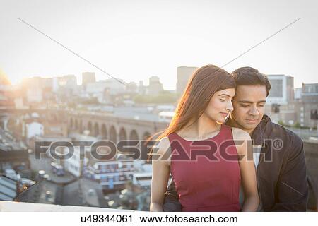 Stock Image - Couple on rooftop, Birmingham, England, UK. Fotosearch