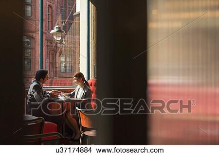 Couple sitting in restaurant booth View Large Photo Image Picture - Couple sitting in restaurant booth. Fotosearch