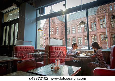 Couple sitting in restaurant booth View Large Photo Image Stock Image - Couple sitting in restaurant booth. Fotosearch