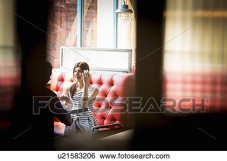Couple sitting in restaurant booth View Large Photo Image Stock Photograph - Couple sitting in restaurant booth. Fotosearch