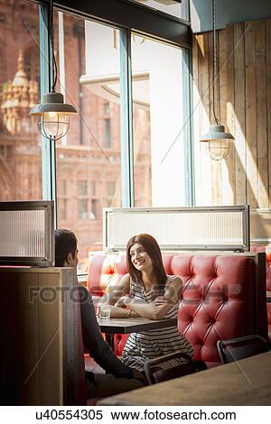 Stock Photography - Couple sitting in restaurant booth. Fotosearch