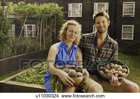 Picture - Couple with harvested potatoes and beets on council estate allotment. Fotosearch