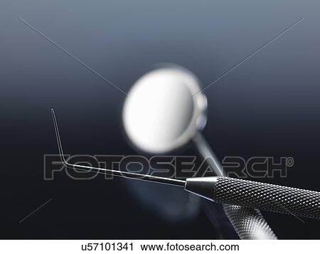 Stock Image - Dental equipment. Pick for checking the integrity of the teeth and removing plaque, and one angled mirror for viewing teeth. Fotosearch