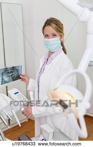 Stock Image - Dentist holding xray image. Fotosearch