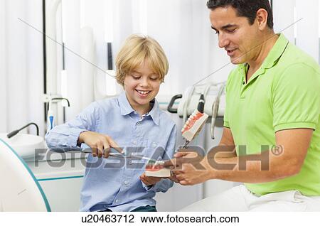 Dentist teaching boy how to brush teeth View Large Photo Image Stock Image - Dentist teaching boy how to brush teeth. Fotosearch