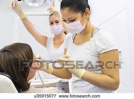 Dentist working on female patient View Large Photo Image Stock Photo - Dentist working on female patient. Fotosearch