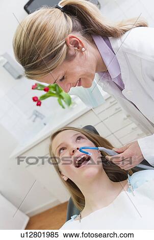 Stock Photography - Dentist working on teenage girl. Fotosearch