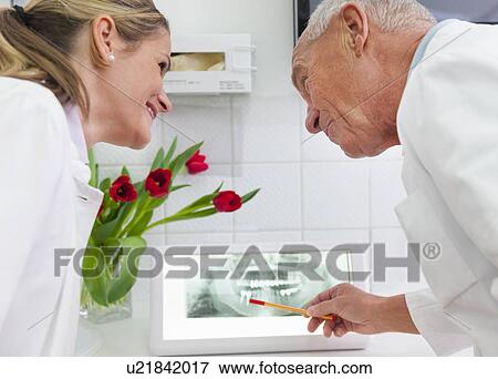 Stock Photo - Dentists examining xray image. Fotosearch
