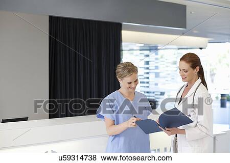 Doctor and nurse looking at paperwork View Large Photo Image Stock Photo - Doctor and nurse looking at paperwork. Fotosearch