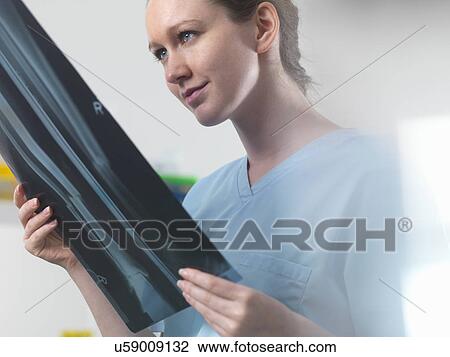 Stock Image - Doctor or radiologist viewing x-ray of broken leg in hospital. Fotosearch