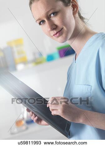 Stock Image - Doctor or radiologist viewing x-ray of broken leg in hospital. Fotosearch