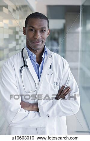Doctor standing in hospital corridor with arms folded View Large Photo Image Stock Image - Doctor standing in hospital corridor with arms folded. Fotosearch
