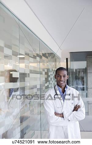 Doctor standing in hospital corridor with arms folded View Large Photo Image Stock Image - Doctor standing in hospital corridor with arms folded. Fotosearch