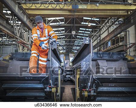 Engineer fixing lifting straps in factory View Large Photo Image Stock Photograph - Engineer fixing lifting straps in factory. Fotosearch