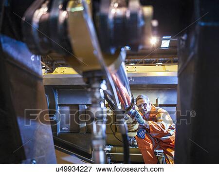 Engineer inspecting steel components in factory View Large Photo Image Stock Photo - Engineer inspecting steel components in factory. Fotosearch