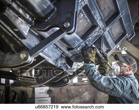 Engineer smoothing welds in factory View Large Photo Image Stock Photo - Engineer smoothing welds in factory. Fotosearch